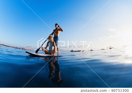 Young happy couple have fun on stand up paddleboard 90731300