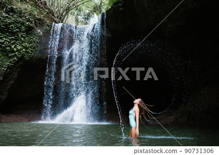 Woman have fun in natural pool under tropical waterfall Woman have fun in natural pool under tropical waterfall 90731306