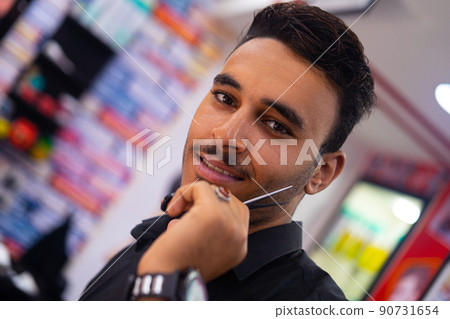 Handsome barber arab man portrait with scissors 90731654
