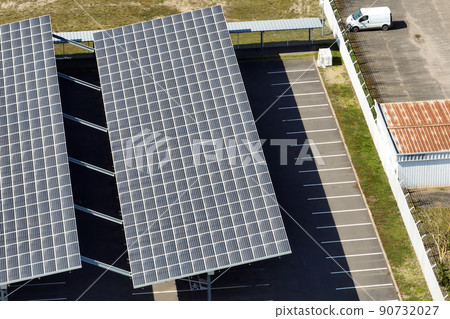 Aerial view of solar panels installed over parking lot with parked cars for effective generation of clean energy 90732027