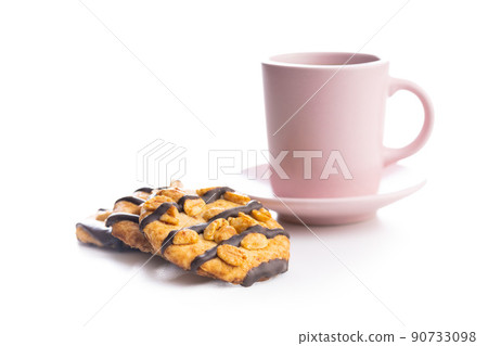 Chip cookies with peanuts and chocolate strips and coffee cup isolated on white background. Chip cookies with peanuts and chocolate strips and coffee cup isolated on white background. 90733098
