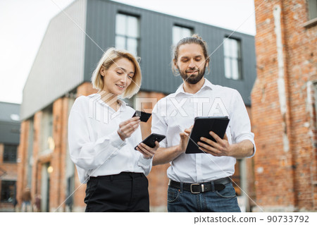 Happy people outdoors shopping online staying on the city street. 90733792