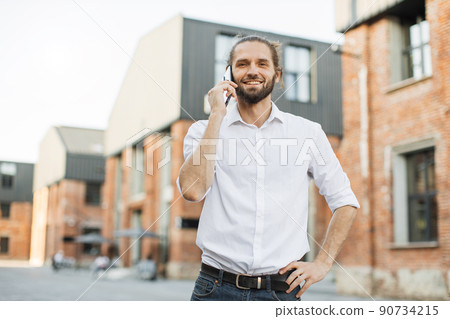 Portrait of smiling young man doing a phone call. Portrait of smiling young man doing a phone call. 90734215