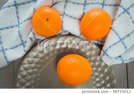 delicious spanish orange on a wooden table, one cut in half.Fresh juicy oranges on the table. delicious spanish orange on a wooden table, one cut in half.Fresh juicy oranges on the table. 90735012