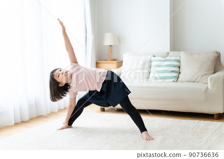 Girl stretching in the living room 90736636