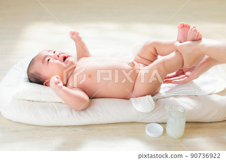 在哭鬧的嬰兒的臀部塗抹保濕霜。出生後 2 個月，尿布疹、尿布皮炎的對策 90736922