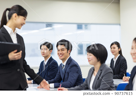 Men and women in suits taking seminars 90737615