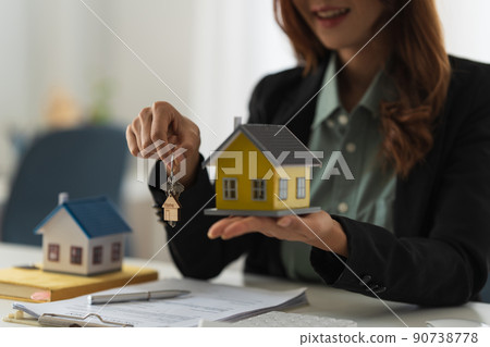 Real estate or broker residential or Agent showing key for house to customer after sign in agreement contract. 90738778