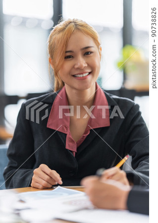 A portrait of Asian happy Businesswoman smiling and working at office. A portrait of Asian happy Businesswoman smiling and working at office. 90738826