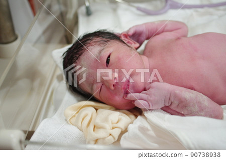 Newborn baby that looks like a wink 90738938