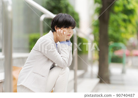 一個女人坐在樓梯上在戶外工作 一個女人坐在樓梯上在戶外工作 90740487