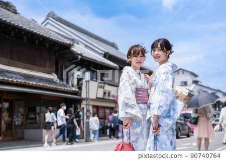 兩個年輕女子租著浴衣走在老街上 90740764