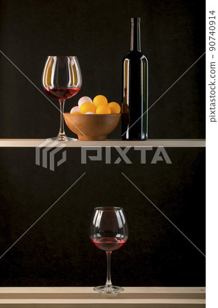 Still life with multicolored balls in a plate, a bottle and glasses of wine 90740914