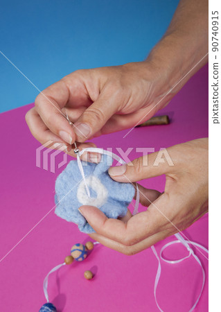 The female hands of the master assemble a handmade product from felted wool The female hands of the master assemble a handmade product from felted wool 90740915