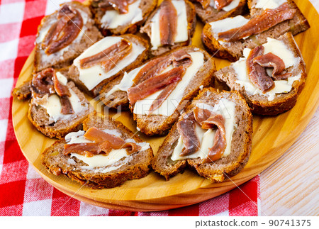 Toasts with salted anchovies and butter Toasts with salted anchovies and butter 90741375