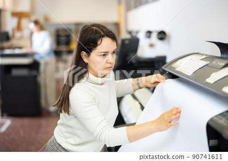 Woman employee of printing house works on modern printer 90741611