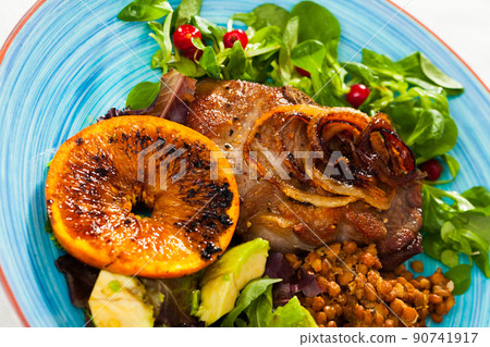 Delicious fried pork chops with avocado, fried orange and greens 90741917