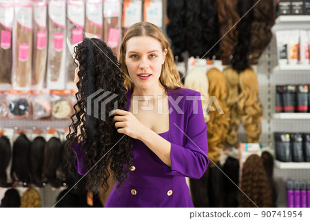 Girl choosing wigs from natural hair Girl choosing wigs from natural hair 90741954