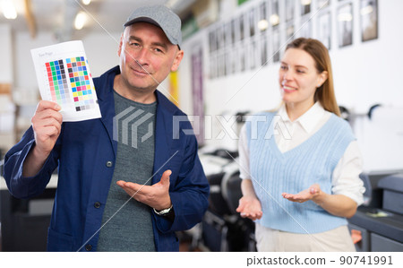 Service engineer and office worker checking color chart test page together clodeup Service engineer and office worker checking color chart test page together clodeup 90741991