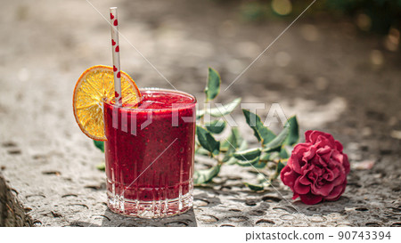Glass of fresh berry smoothie with orange slice Glass of fresh berry smoothie with orange slice 90743394