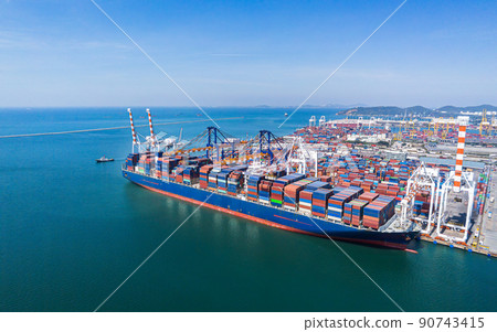 Arial view by drone camera transportation logistics and container dock cargo yard with working crane bridge in shipyard with transport logistic import export with blue sky background. 90743415