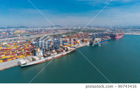 Arial view by drone camera transportation logistics and container dock cargo yard with working crane bridge in shipyard with transport logistic import export with blue sky background. 90743416