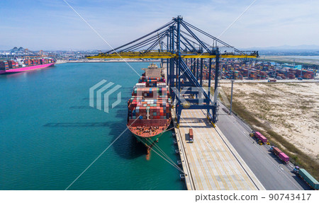 Arial view by drone camera transportation logistics and container dock cargo yard with working crane bridge in shipyard with transport logistic import export with blue sky background. 90743417