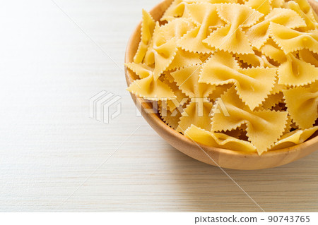 Dry uncooked farfalle pasta in bowl 90743765