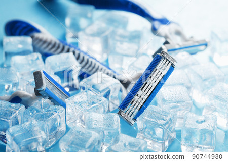 Three shaving machines on a frosty blue background with ice. The concept of cleanliness and frosty freshness Three shaving machines on a frosty blue background with ice. The concept of cleanliness and frosty freshness 90744980