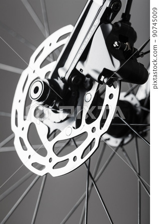 Shiny bicycle brake rotor close-up in macro with selective focus Shiny bicycle brake rotor close-up in macro with selective focus 90745009