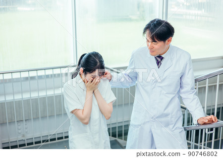 Male doctor encouraging crying nurses Male doctor encouraging crying nurses 90746802
