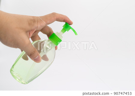 Asian mand hand holds a gel alcohol pump bottle and ready to pushes on it. It's an isolated object on the white clear screen in studio light. Asian mand hand holds a gel alcohol pump bottle and ready to pushes on it. It's an isolated object on the white clear screen in studio light. 90747453