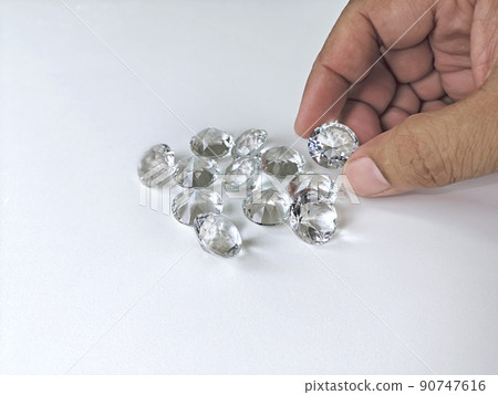Close-up of the hand of jeweller gemologist with round cut diamonds 90747616