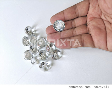 Close-up of the hand of jeweller gemologist with round cut diamonds 90747617