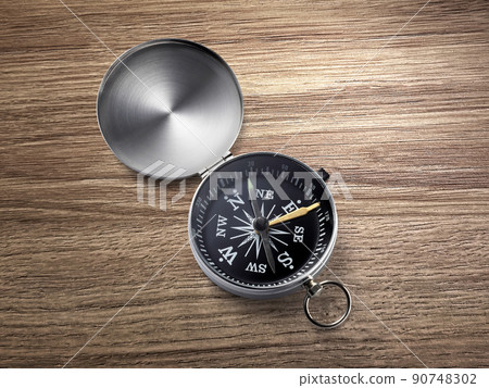 compass on the brown wooden table background compass on the brown wooden table background 90748302