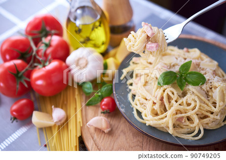 homemade pasta carbonara with fresh basil and parmesan in ceramic dish homemade pasta carbonara with fresh basil and parmesan in ceramic dish 90749205