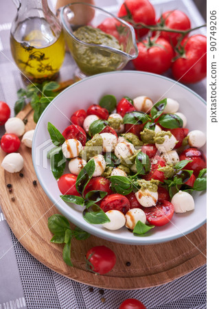 Caprese salad - Mini mozzarella cheese in glass bowl, tomato and basil Caprese salad - Mini mozzarella cheese in glass bowl, tomato and basil 90749206
