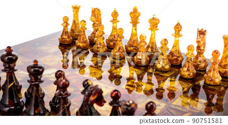 Natural amber different chess pieces figures standing on brown stone board. Close up game concept competition, Classic Gambit Tournament of confrontation. 90751581