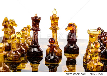 Natural amber different chess pieces figures standing on brown stone board. Close up game concept competition, Classic Gambit Tournament of confrontation. 90751583