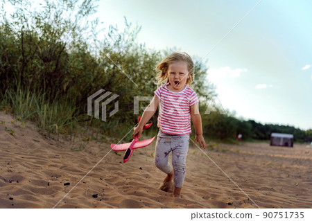 caucasian little girl holding toy plane in hands caucasian little girl holding toy plane in hands 90751735