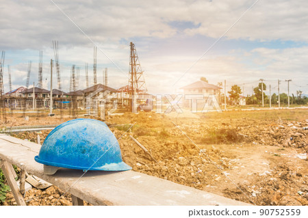 Blue hard hat on house building construction site Blue hard hat on house building construction site 90752559
