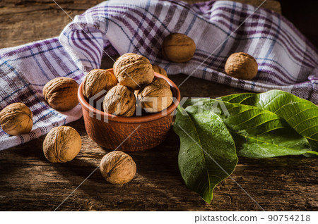 Walnut kernels on a dark table with a colored background Walnut kernels on a dark table with a colored background 90754218