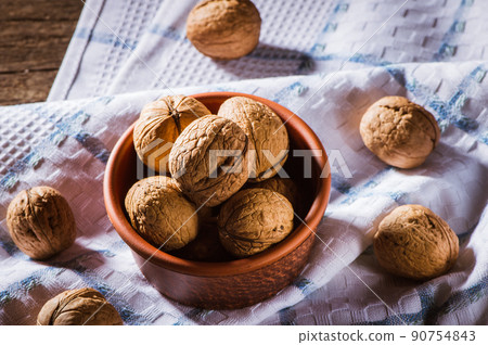 Walnut kernels and whole walnuts on an old wooden 90754843