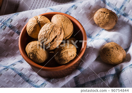 Walnut kernels and whole walnuts on an old wooden 90754844