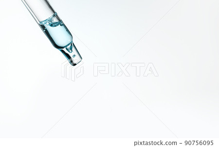 Closeup of pipette with serum, hyaluronic acid on blue background. Cosmetics and healthcare concept. Dose of essential oill, retinol with air bubbles. Beauty product presentation, front view, macro Closeup of pipette with serum, hyaluronic acid on blue background. Cosmetics and healthcare concept. Dose of essential oill, retinol with air bubbles. Beauty product presentation, front view, macro 90756095