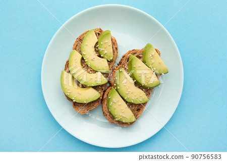 Fresh avocado, bread and sesame sandwich. Food for a healthy diet. Flat lay. Top view. Tasty breakfast. Fresh avocado, bread and sesame sandwich. Food for a healthy diet. Flat lay. Top view. Tasty breakfast. 90756583