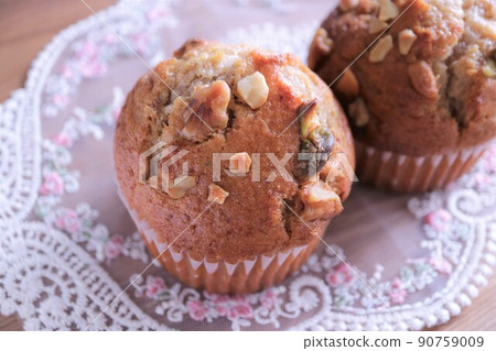 Muffins on a white lace Muffins with nuts Two muffins lined up 90759009