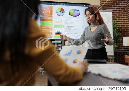 Asian manager discussing management statistics with entrepreneur woman during business meeting in startup office. Businesswomen working at company strategy planning marketing project Asian manager discussing management statistics with entrepreneur woman during business meeting in startup office. Businesswomen working at company strategy planning marketing project 90759105