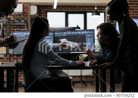 Production department team gathered around 3D artist engineer trying to solve geometry problem. Digital engineering experts collaborating in order to develop advanced scene. 90759252