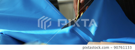 Atelier worker cutting blue cloth with scissors for further sewing Atelier worker cutting blue cloth with scissors for further sewing 90761133